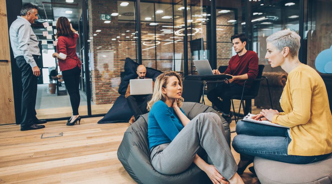 a group of people sitting on bean bags in a workspace